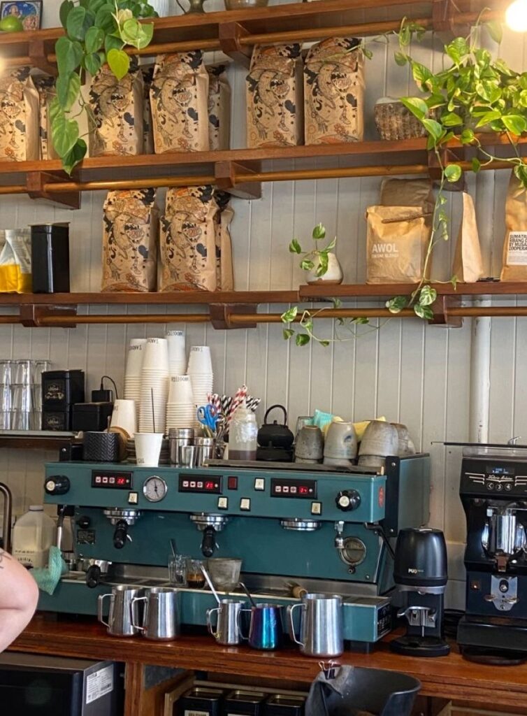 Comptoir d'un café où l'on voit une machine et des sacs de café